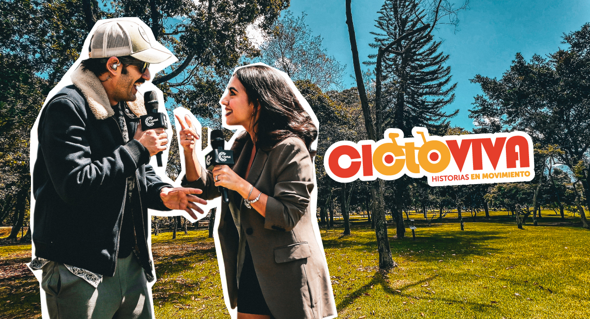 Al fondo de la imagen hay un parque en Bogotá. Adelante hay un hombre hablando con una mujer