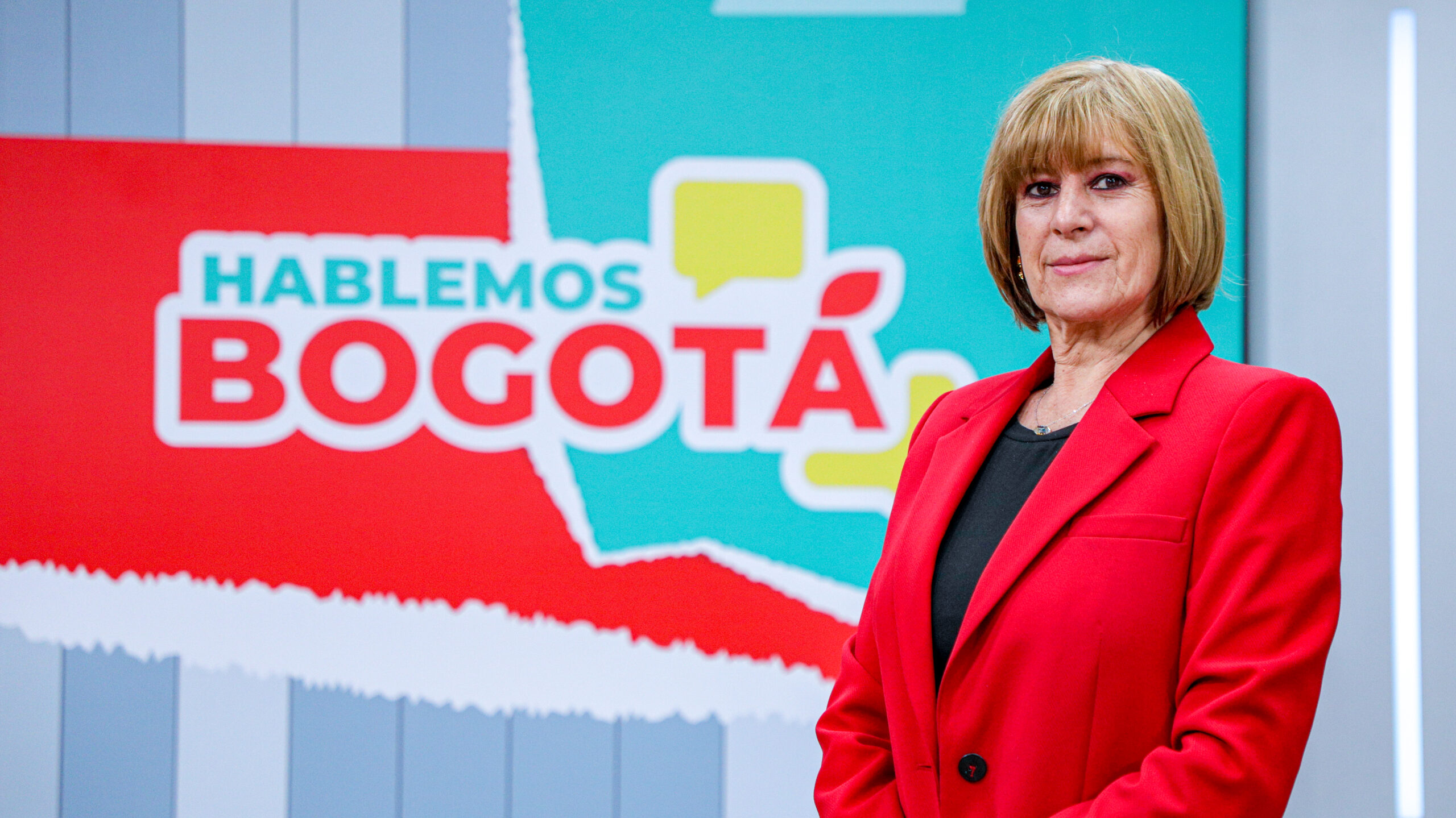 Julia Navarrete, jefe de emisión de Hablemos Bogotá con saco color rojo, en el set de Hablemos Bogotá.