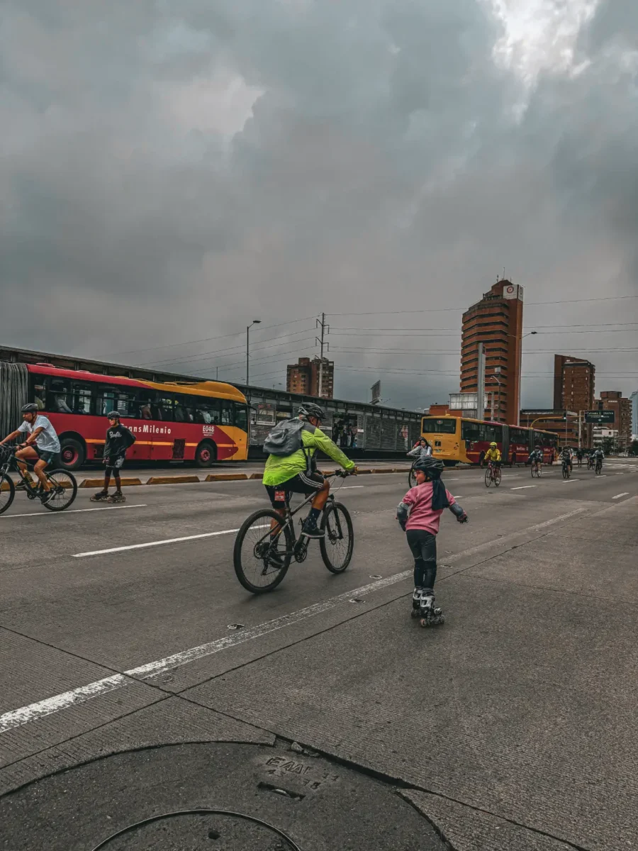 Familias haciendo deporte juntos, se pueden observar personas en bicicletas y niños en patines durante la ciclovía en Bogotá