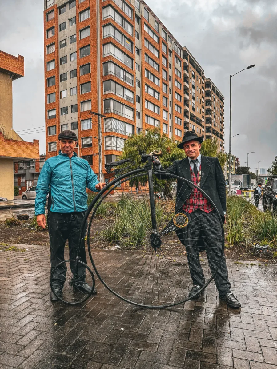 Dos hombres con un velocípedo en la ciclovía de Bogotá