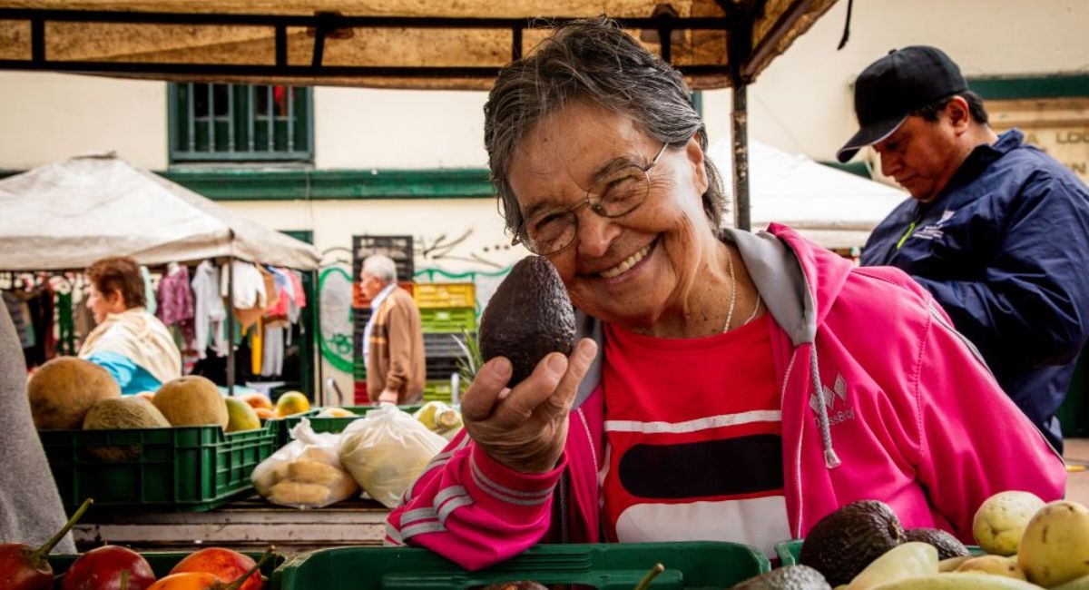 Mujer campesina mostrando un aguacate