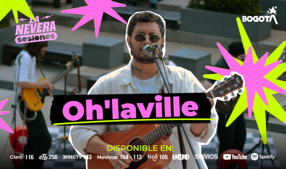 Cantante de Oh’laville con gafas oscuras interpreta guitarra y canta frente a micrófono en presentación en vivo, acompañado por otros músicos en La Nevera Sesiones en Bogotá