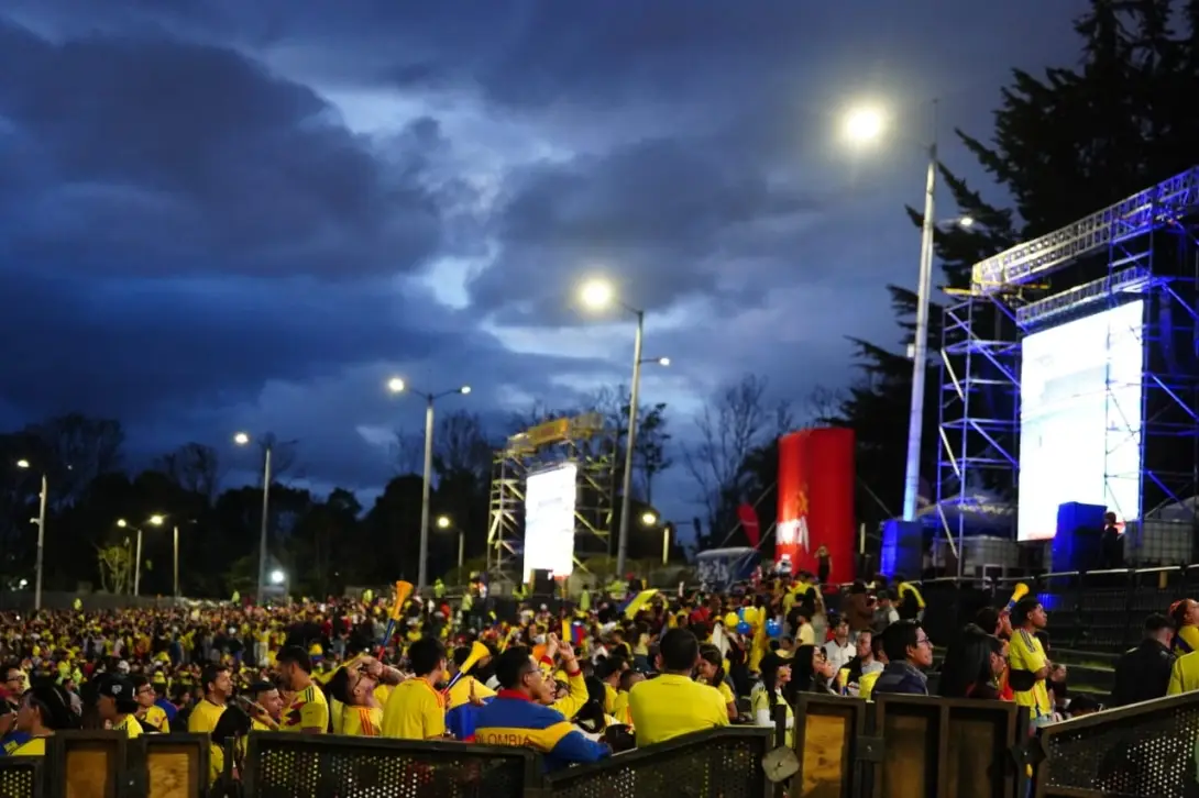 Personas ven un partido de la Selección Colombia al aire libre en una pantalla gigante