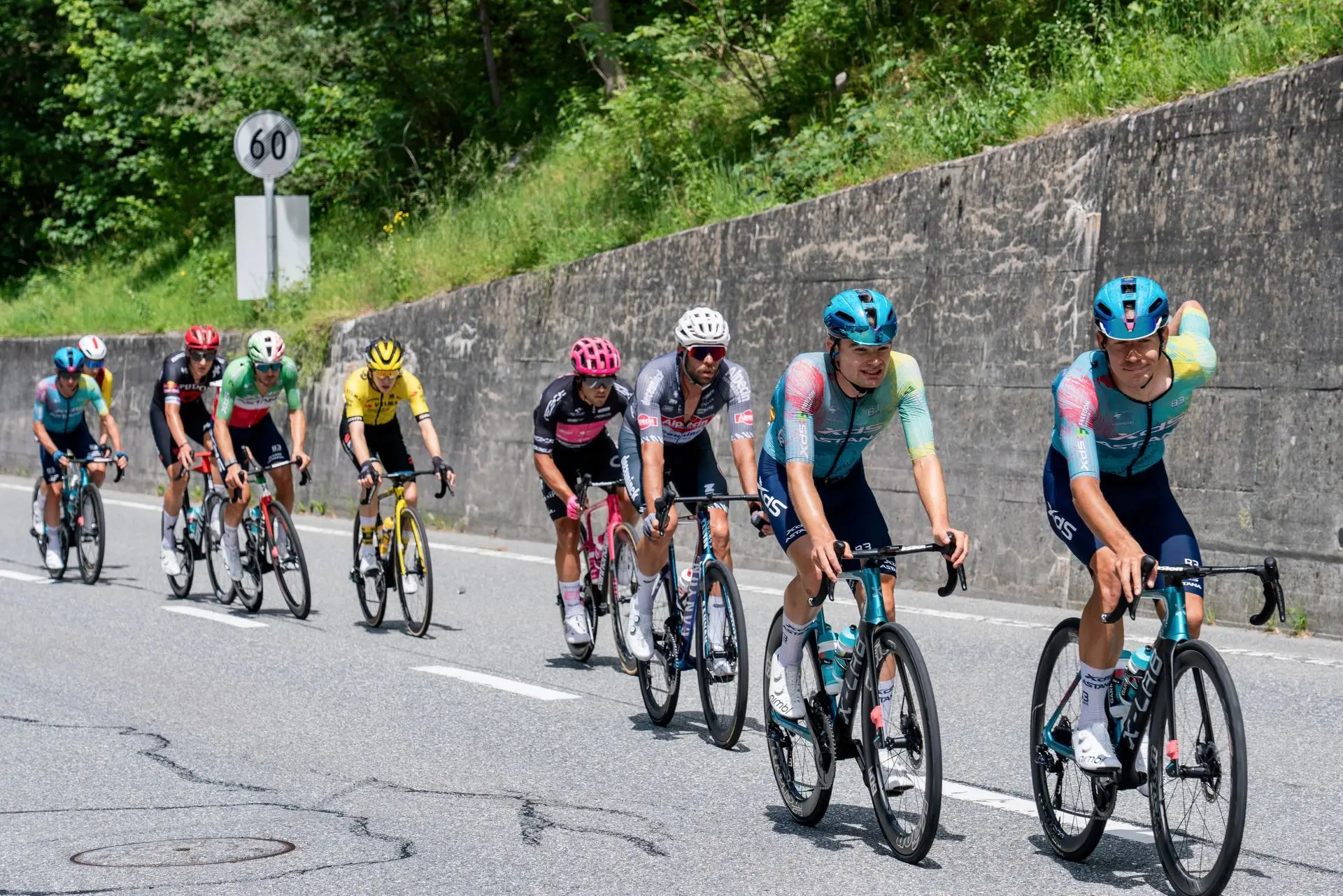 Ciclistas compitiendo en una carrera en una pintoresca carretera de montaña en verano.
